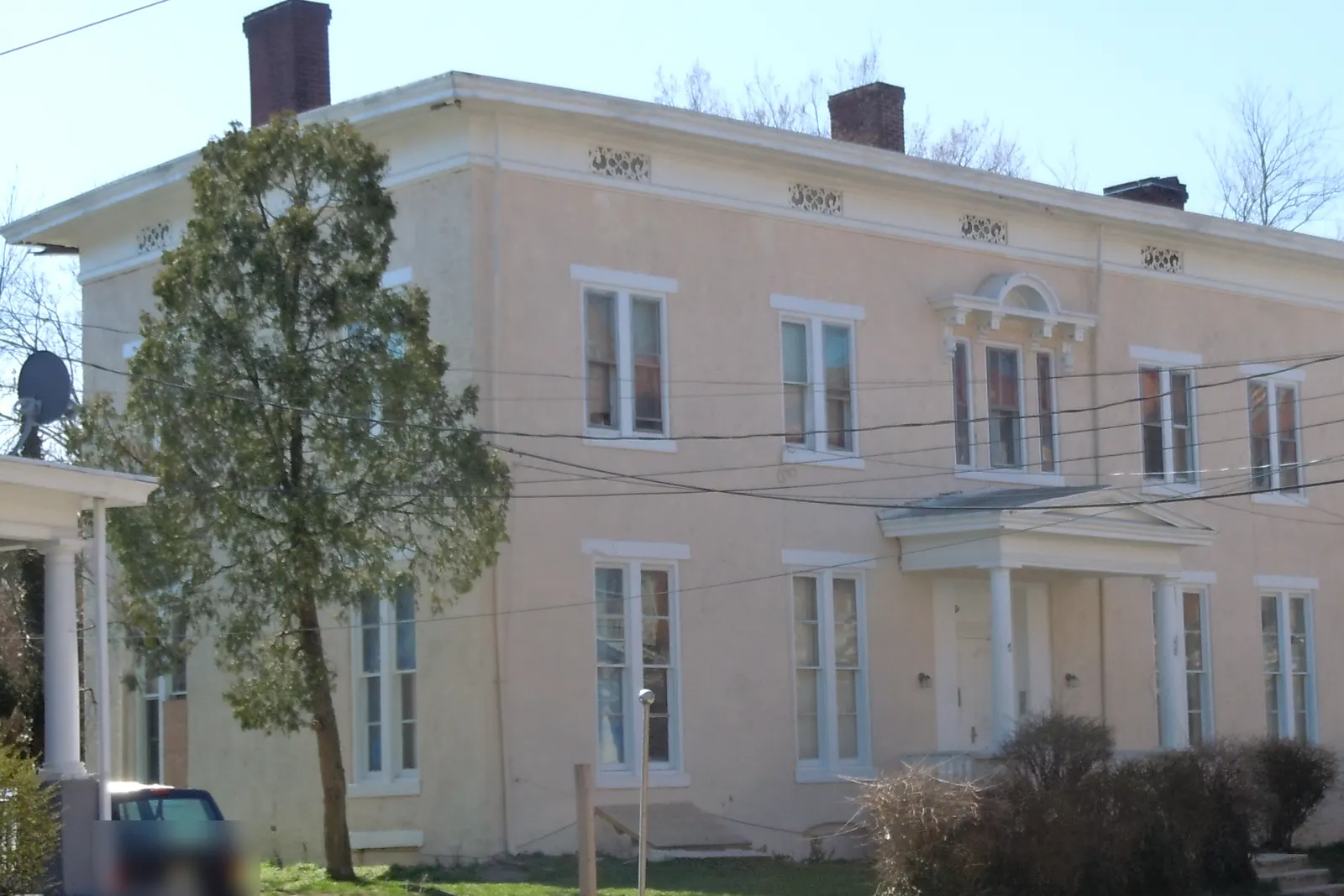 A two-story painted house in Trenton, New Jersey, with tall windows and a columned entry
